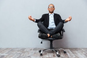Man meditating on office chair